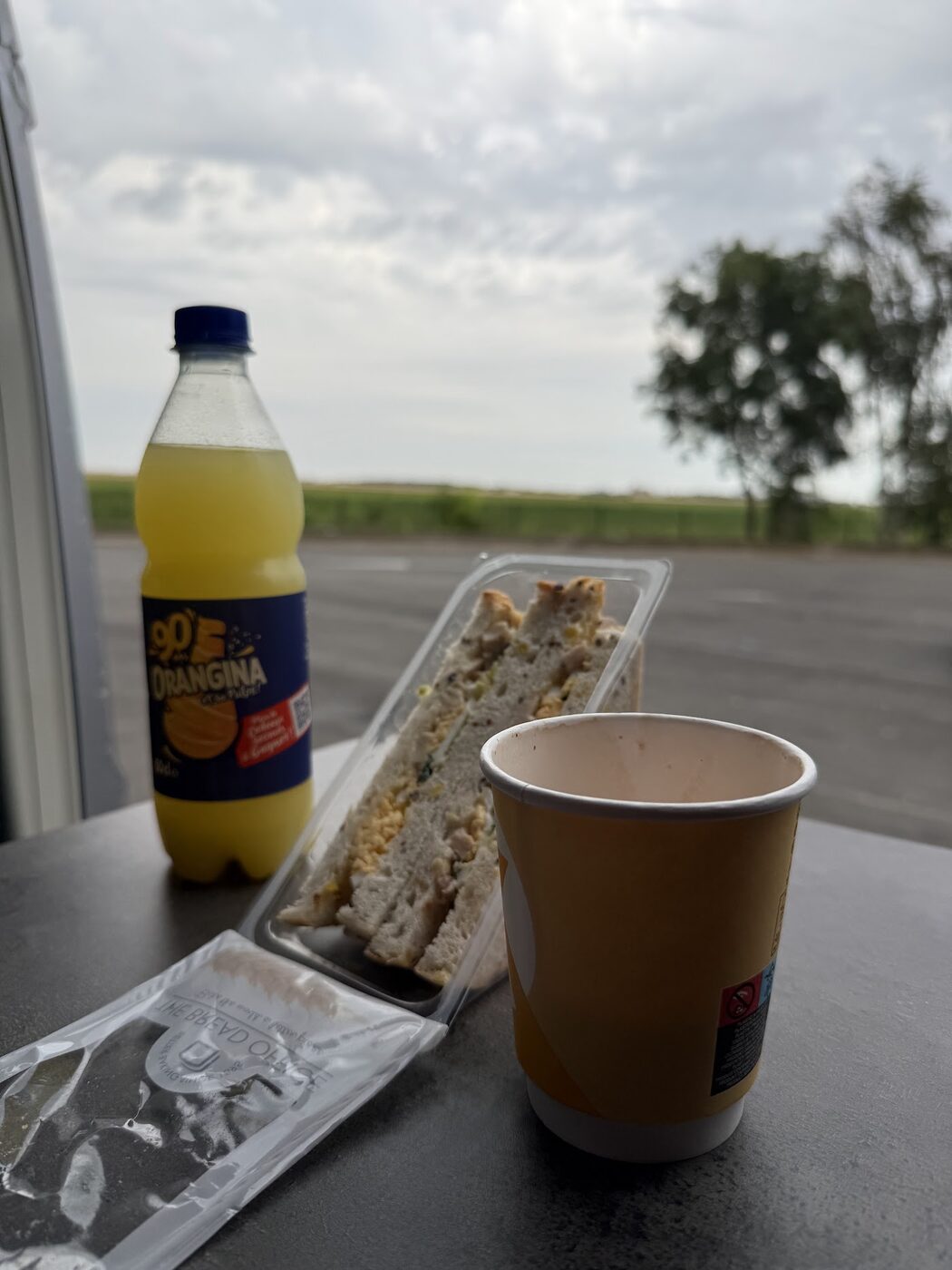 De eerste stop onderweg. Koffie uit een kartonnen beker, en toch al vakantie.